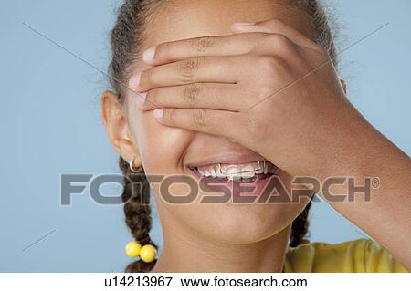 Studio shot of girl (10-11) covering eyes with hand View Large Photo Image Stock Photo - Studio shot of girl (10-11) covering eyes with hand. Fotosearch