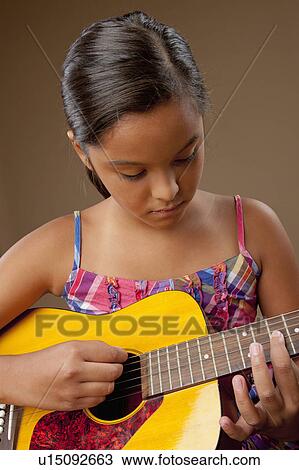 Studio shot of girl (10-11) playing guitar View Large Photo Image Stock Image - Studio shot of girl (10-11) playing guitar. Fotosearch