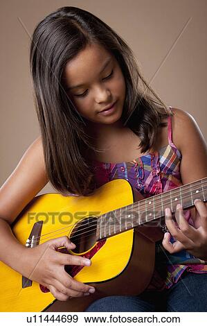 Studio shot of girl (10-11) playing guitar View Large Photo Image Stock Photo - Studio shot of girl (10-11) playing guitar. Fotosearch