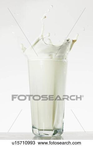 Stock Image - Studio shot of glass of milk with splash. Fotosearch