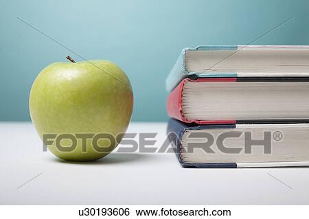 Studio shot of green apple and textbooks View Large Photo Image Stock Photograph - Studio shot of green apple and textbooks. Fotosearch