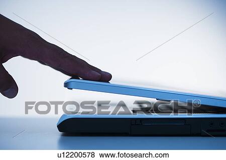Studio shot of hand closing laptop View Large Photo Image Stock Photo - Studio shot of hand closing laptop. Fotosearch