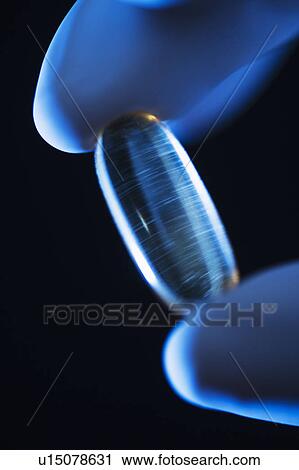 Studio shot of hand holding capsule View Large Photo Image Stock Image - Studio shot of hand holding capsule. Fotosearch