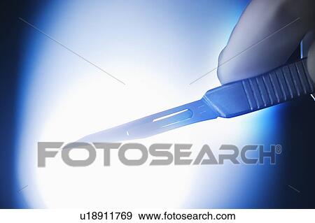 Studio shot of hand holding scalpel View Large Photo Image Stock Photo - Studio shot of hand holding scalpel. Fotosearch