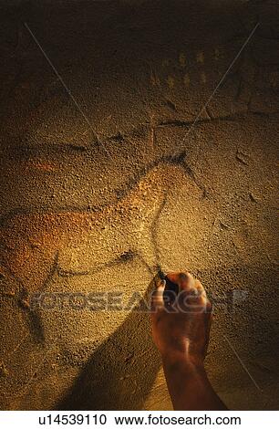 Stock Image - Studio shot of hand making cave painting of horse. Fotosearch