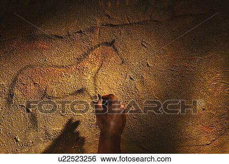 Stock Photograph - Studio shot of hand making cave painting of horse. Fotosearch