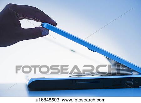 Studio shot of hand opening laptop View Large Photo Image Stock Image - Studio shot of hand opening laptop. Fotosearch