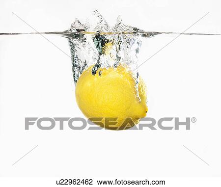 Stock Image - Studio shot of lemon splashing into water. Fotosearch