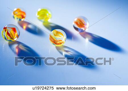 Stock Photography - Studio shot of marble ball on blue background. Fotosearch