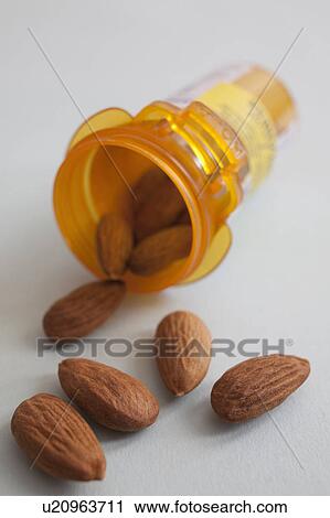 Stock Image - Studio shot of pill bottle with almonds. Fotosearch