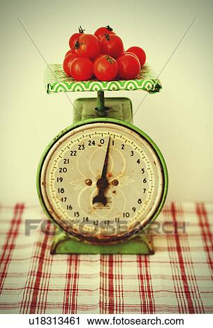 Stock Image - Studio shot of tomatoes on scales. Fotosearch