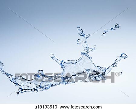 Stock Image - Studio shot of water splash on blue background. Fotosearch