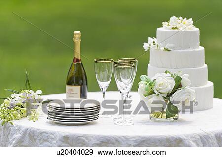 Stock Photo - Table with champagne bottle and wedding cake. Fotosearch