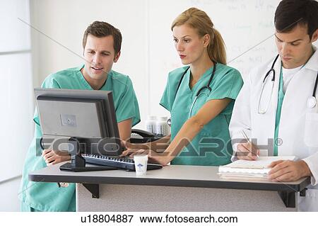 Team of doctors looking at computer View Large Photo Image Stock Photo - Team of doctors looking at computer. Fotosearch