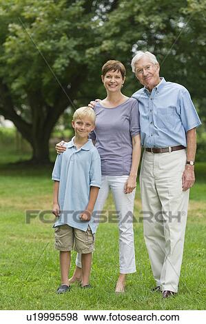 Three generation family standing in park View Large Photo Image Stock Photo - Three generation family standing in park. Fotosearch