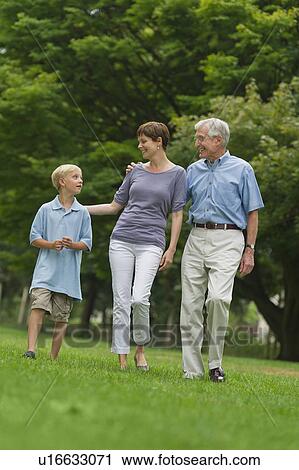 Stock Image - Three generation family walking in park. Fotosearch