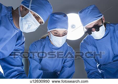 Stock Image - Three surgeons operating. Fotosearch