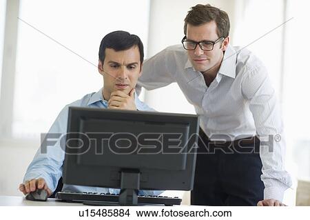 Picture - Two businessmen looking at computer. Fotosearch