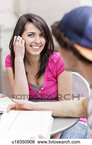 Two college students sitting at cafe table View Large Photo Image Stock Photo - Two college students sitting at cafe table. Fotosearch