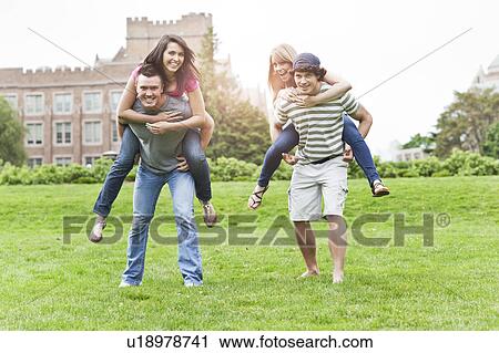 Stock Image - Two couples piggybacking on campus. Fotosearch