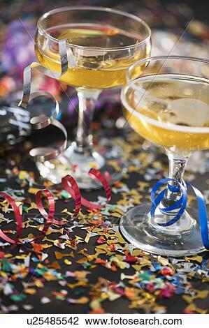 Stock Image - Two glasses of champagne and confetti. Fotosearch