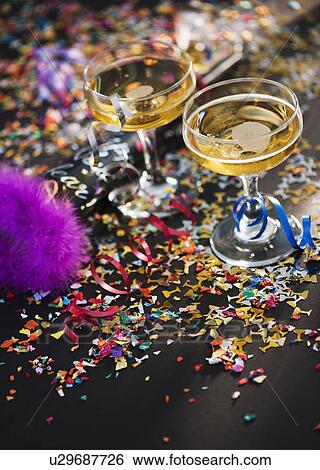 Two glasses of champagne and confetti View Large Photo Image Stock Photograph - Two glasses of champagne and confetti. Fotosearch