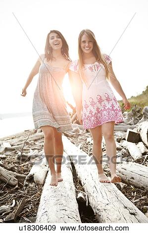 Stock Photo - Two young women balancing on logs. Fotosearch