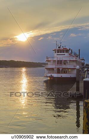Stock Image - USA, Georgia, Savannah, Passenger ship moored at pier at sunset. Fotosearch