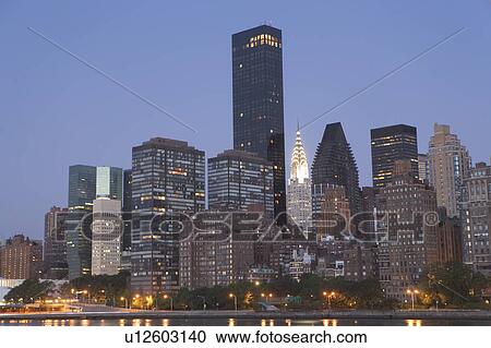 Stock Image - USA, New York State, New York City, Manhattan, Skyscrapers of Manhattan at dusk. Fotosearch