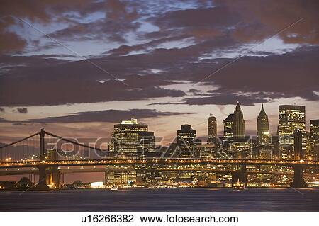 Stock Image - USA, New York State, New York City, Manhattan, Skyscrapers of Manhattan at dusk. Fotosearch
