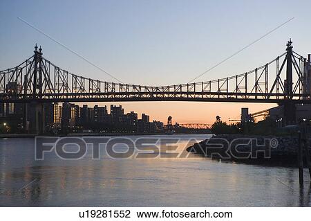 Stock Image - USA, New York State, New York City, Manhattan, Queensboro bridge at dusk. Fotosearch