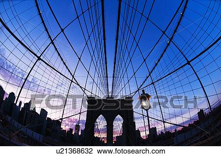Stock Image - USA, New York State, New York City, Manhattan, Brooklyn Bridge at dusk. Fotosearch