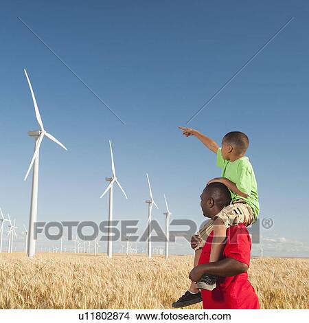 USA, Oregon, Wasco, Boy (8-9) piggy-back riding on father pointing at wind turbines View Large Photo Image Picture - USA, Oregon, Wasco, Boy (8-9) piggy-back riding on father pointing at wind turbines. Fotosearch