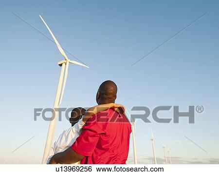 Stock Photograph - USA, Oregon, Wasco, Father and son (8-9) watching wind turbine. Fotosearch