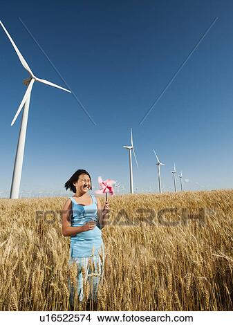 USA, Oregon, Wasco, Girl (10-11) holding fan in wheat field with wind turbines in background View Large Photo Image Picture - USA, Oregon, Wasco, Girl (10-11) holding fan in wheat field with wind turbines in background. Fotosearch