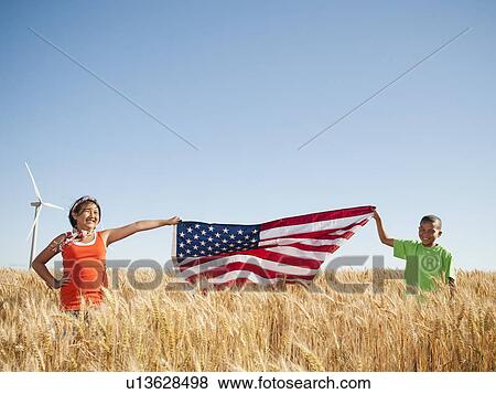 USA, Oregon, Wasco, Girl (10-110 and boy (8-9) holding american flag in wheat field, wind turbine in background View Large Photo Image Stock Photo - USA, Oregon, Wasco, Girl (10-110 and boy (8-9) holding american flag in wheat field, wind turbine in background. Fotosearch