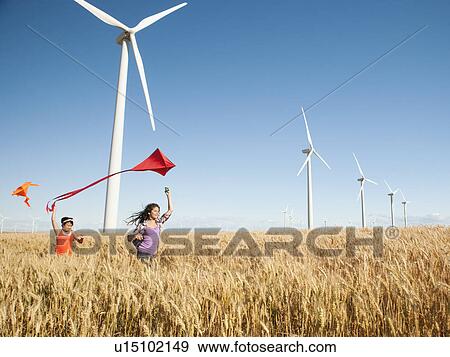USA, Oregon, Wasco, Girls (10-11, 12-13) playing with kite in wheat field, wind turbines in background View Large Photo Image Stock Photo - USA, Oregon, Wasco, Girls (10-11, 12-13) playing with kite in wheat field, wind turbines in background. Fotosearch