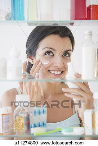 Woman applying lotion on face View Large Photo Image Stock Image - Woman applying lotion on face. Fotosearch