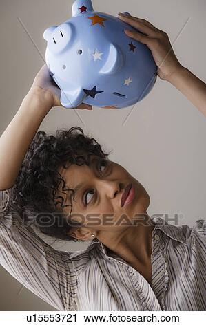 Stock Image - Woman holding piggybank. Fotosearch