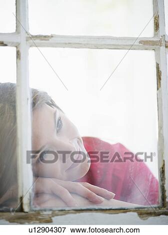 Stock Photo - Woman looking through window. Fotosearch
