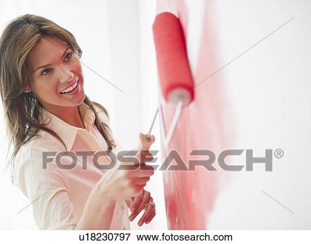 Woman painting wall with rollerpaint View Large Photo Image Stock Photo - Woman painting wall with rollerpaint. Fotosearch