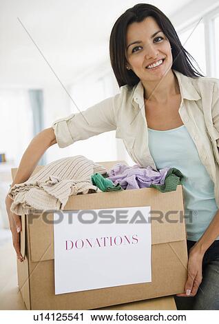 Woman preparing clothes for charity View Large Photo Image Stock Image - Woman preparing clothes for charity. Fotosearch