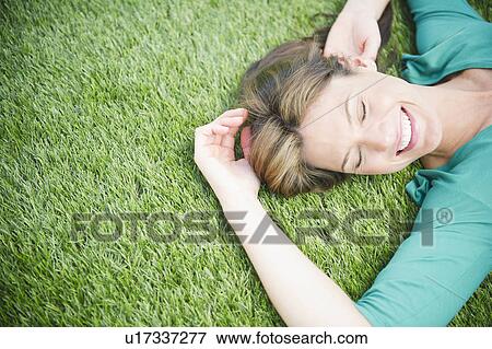 Woman relaxing on grass View Large Photo Image Stock Photo - Woman relaxing on grass. Fotosearch