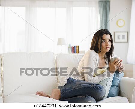 Stock Image - Woman relaxing on sofa . Fotosearch