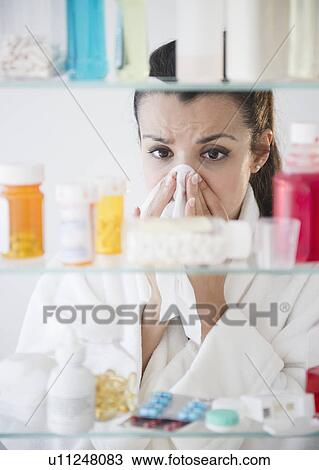 Woman sneezing and using tissue View Large Photo Image Stock Image - Woman sneezing and using tissue. Fotosearch