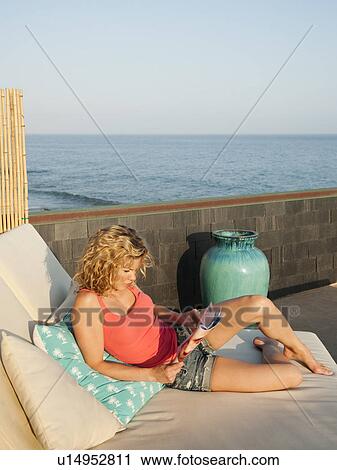 Stock Image - Young attractive woman sunbathing. Fotosearch