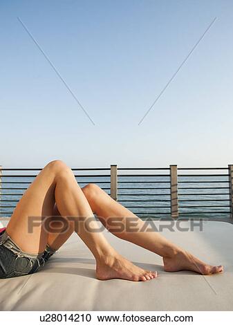 Stock Image - Young attractive woman sunbathing. Fotosearch
