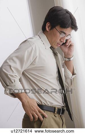 Picture - Young businessman using cell phone. Fotosearch