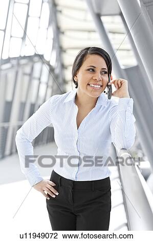 Stock Image - Young businesswoman talking on phone. Fotosearch