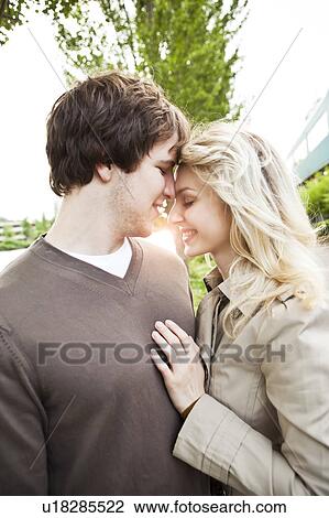 Young couple being affectionate at sunset View Large Photo Image Stock Image - Young couple being affectionate at sunset. Fotosearch